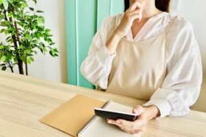 電卓で計算するエプロン姿の女性