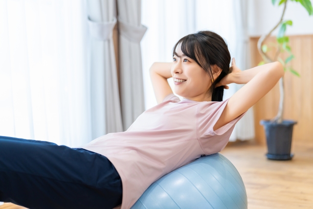 バランスボールで運動をする女性